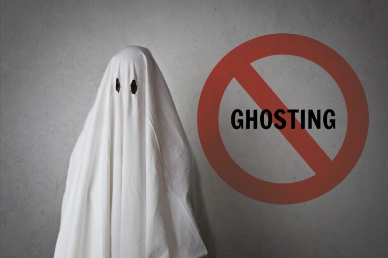 A person in a white sheet standing next to a no ghosting sign.