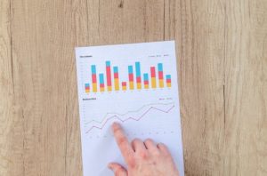 A person pointing to a chart on top of a table.