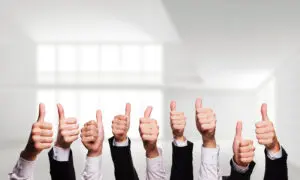 A group of people holding up thumbs up.