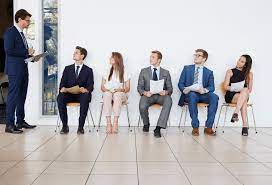 A group of people sitting in chairs waiting for an interview.