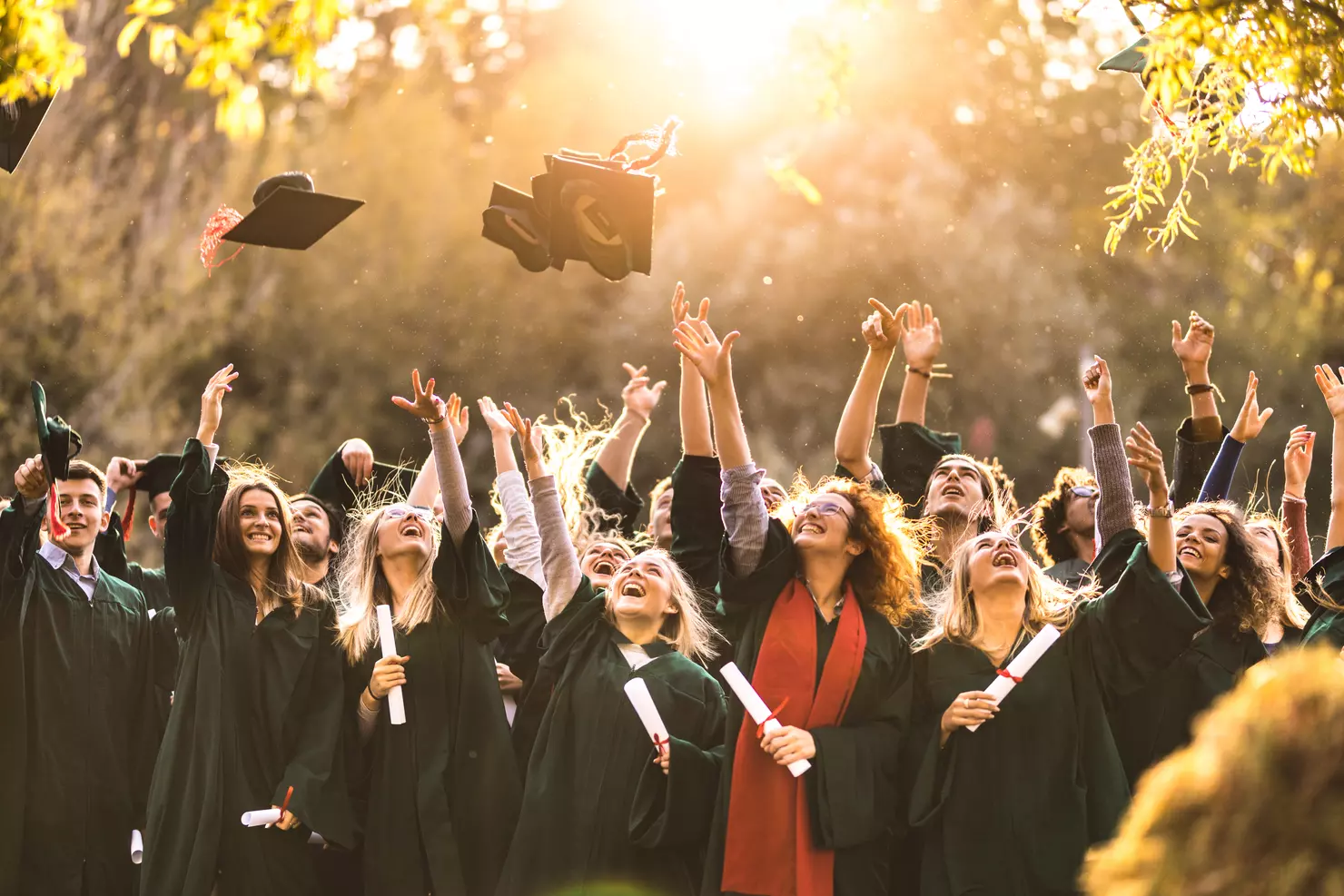 A group of so many people throwing cap in the air