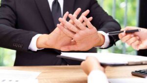 Man refusing to sign a document.